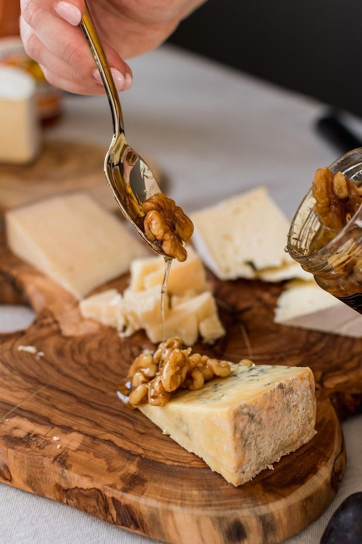 A spoon of honeyed walnuts over blue cheese